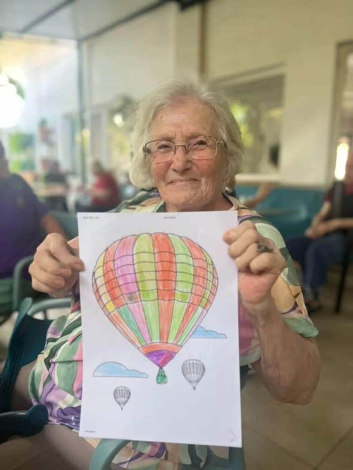 Atölyede yaptığı balon resmini gösteren, gülümseyen bir sakinimiz